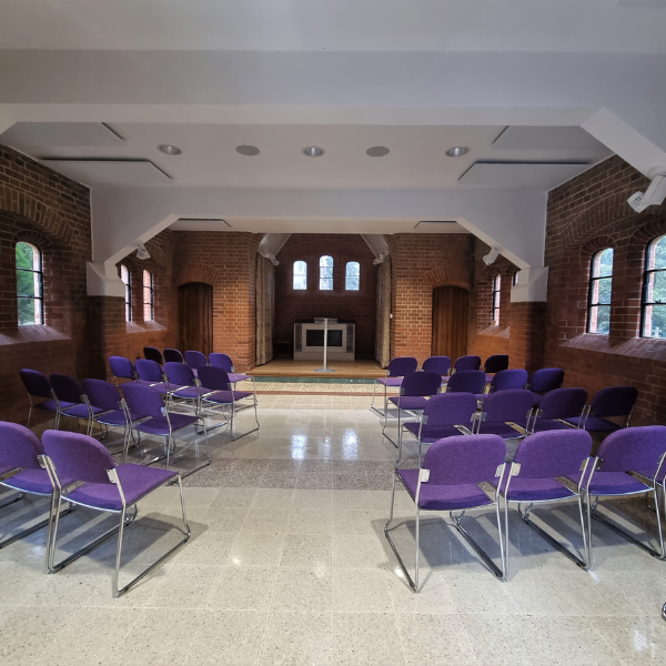 Brookwood Cemetery Chapel interior. Chairs are set out in rows with a central aisle.